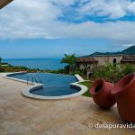 View of an infinity pool and the Pacific Ocean from the patio of a hillside house in Costa Rica.