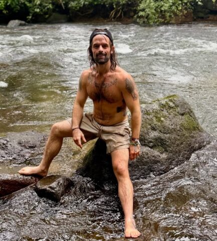 Joe Felz exploring nature near water on the rock